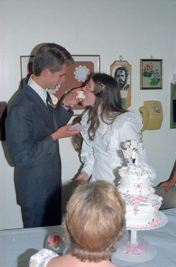 Don and Lois Colton at their wedding reception, Don feeds cake to Lois, 1975